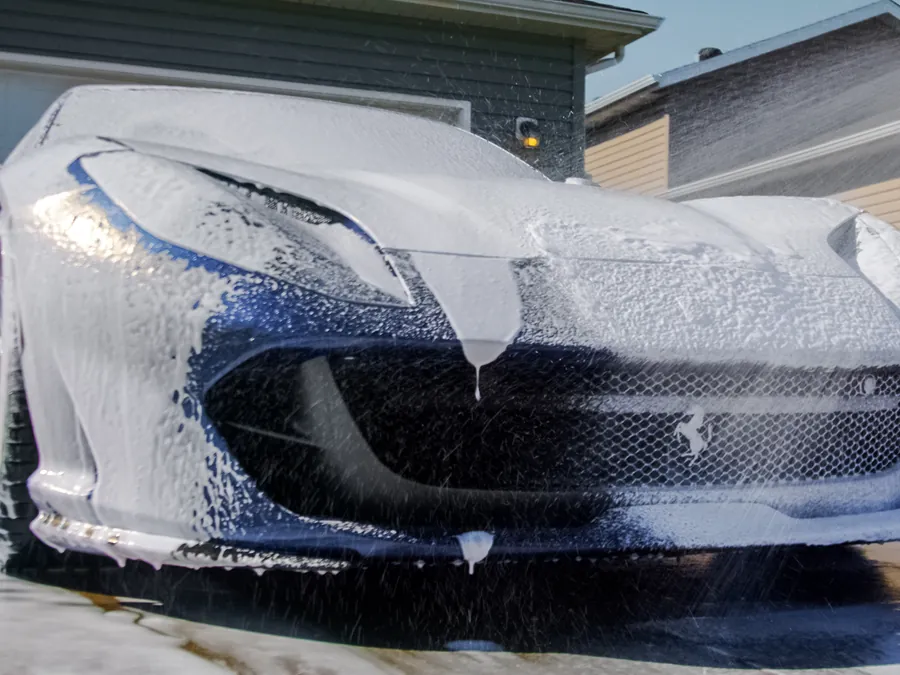 Ferrari covered in thick snow foam during a hand wash